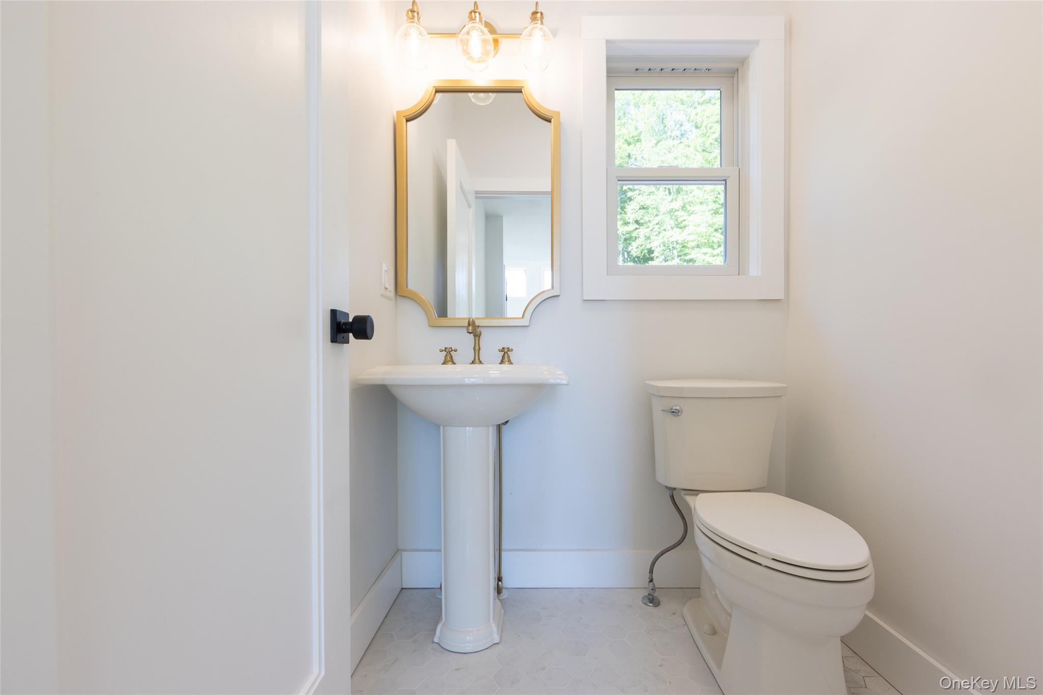 91 Lenni Lenape Road Narrowsburg, NY 12764 - Photo 10 of 25 Pedestal sink with brass-finish faucet, framed mirror, and coordinating lighting fixture