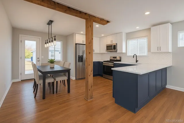 a kitchen with a kitchen island hardwood floor sink stove dining table and chairs