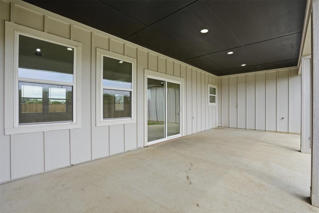 532 Highview Court Godley, TX 76044 - Photo 35 of 39 Covered patio with a concrete surface, featuring board and batten siding, recessed lighting, and a sliding glass door