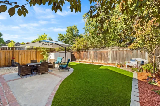 a view of backyard with outdoor seating and trees