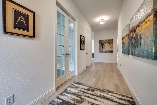 a view of a hallway with wooden floor and a living room