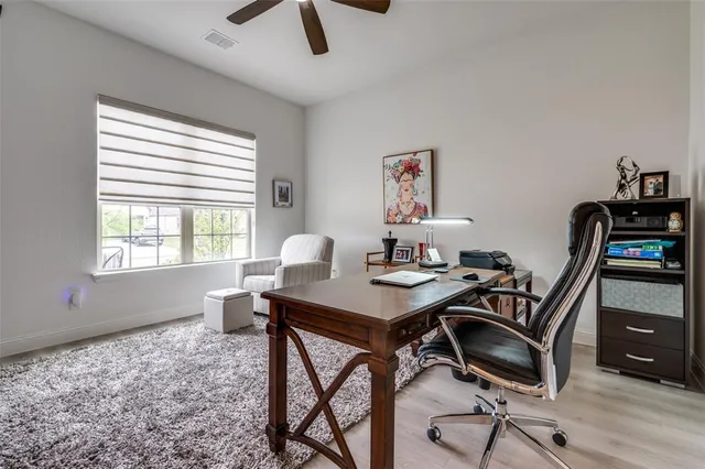 a view of a workspace with furniture and a window