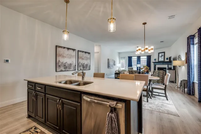 a kitchen with kitchen island granite countertop a sink a center island and chairs