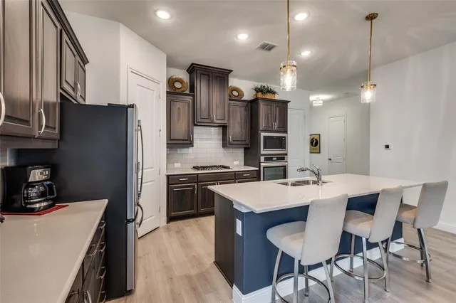 a kitchen with stainless steel appliances a sink stove and refrigerator