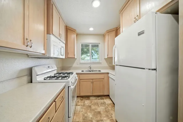 a kitchen with a refrigerator a stove a microwave and cabinets