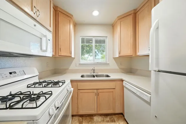 a kitchen with a white stove top oven and sink