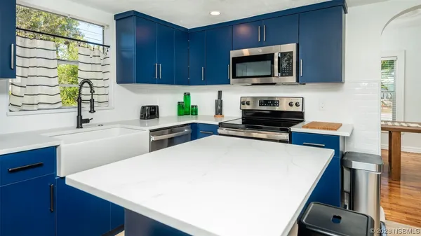 a kitchen with stainless steel appliances a stove a refrigerator a sink a stove and cabinets