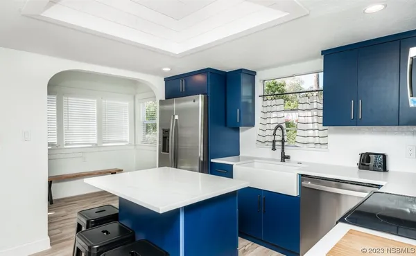 a kitchen with stainless steel appliances a sink a refrigerator and wooden cabinets