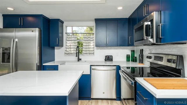 a kitchen with a sink and a stove with wooden floor