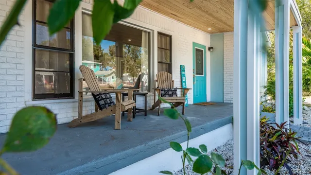a view of a porch with chairs and potted plants