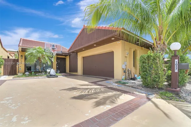 a front view of house along with road and trees