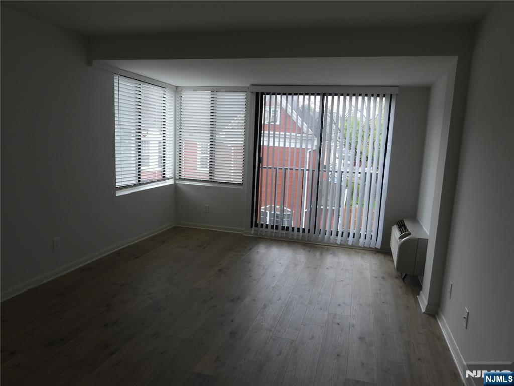 55 Clinton Place, Unit 301 Hackensack, NJ 07601 - Photo 14 of 17 an empty room with wooden floor and windows