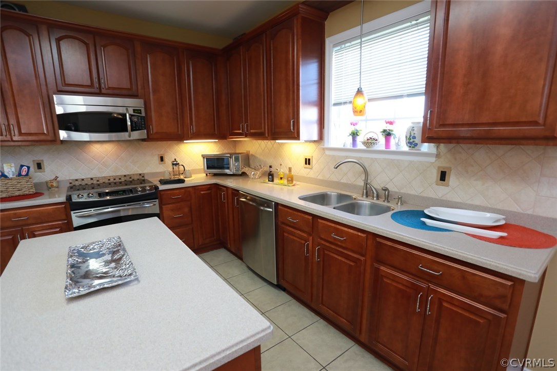 3006 Burley Ridge Terrace Chester, VA 23831 - Photo 15 of 37 a kitchen with stainless steel appliances granite countertop wooden cabinets a stove a sink and a window
