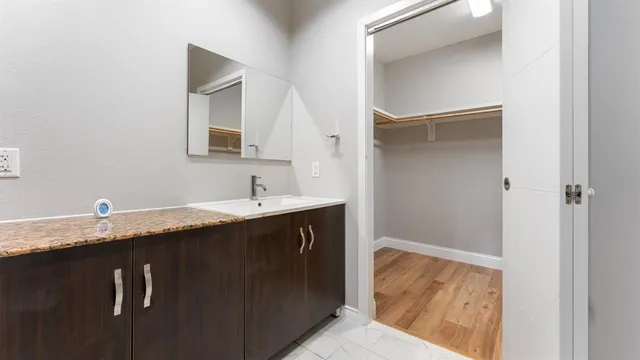 a bathroom with a granite countertop sink and a mirror