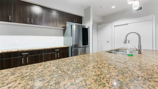 a kitchen with kitchen island sink and refrigerator