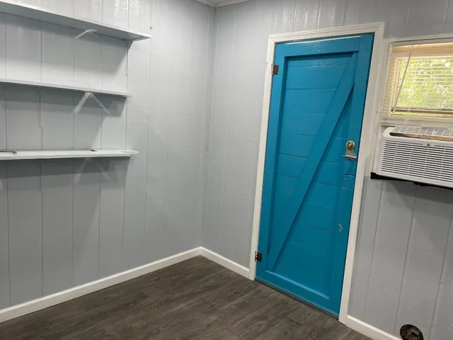 a view of an empty room with closet and wooden floor