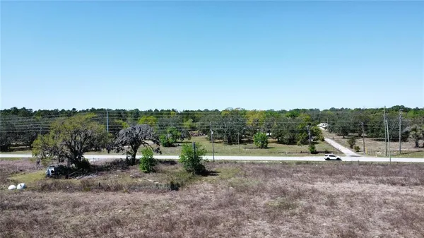a view of a field with trees in background