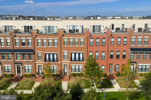 a front view of a residential apartment building with a yard and lake view
