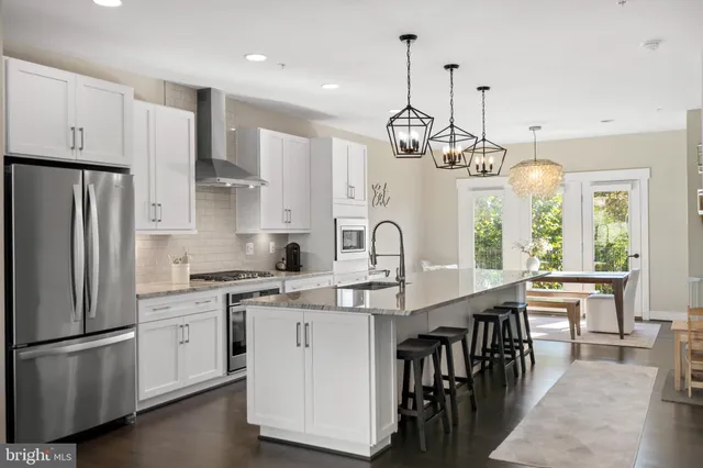 a kitchen with kitchen island granite countertop a sink a center island and stainless steel appliances