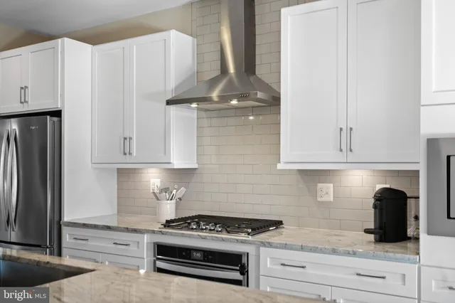 a kitchen with stainless steel appliances granite countertop a sink a stove a dining table and chairs