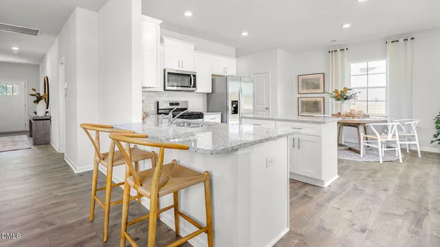 a kitchen with stainless steel appliances kitchen island granite countertop a refrigerator and microwave