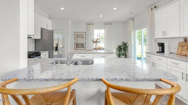 a kitchen with granite countertop kitchen island stainless steel appliances a sink table and chairs