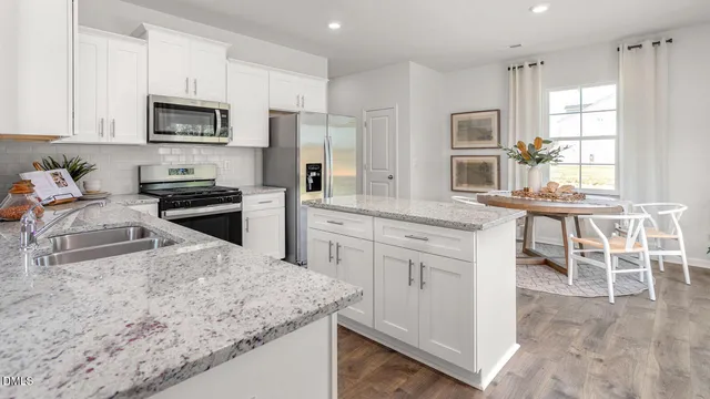a kitchen with granite countertop white cabinets and stainless steel appliances
