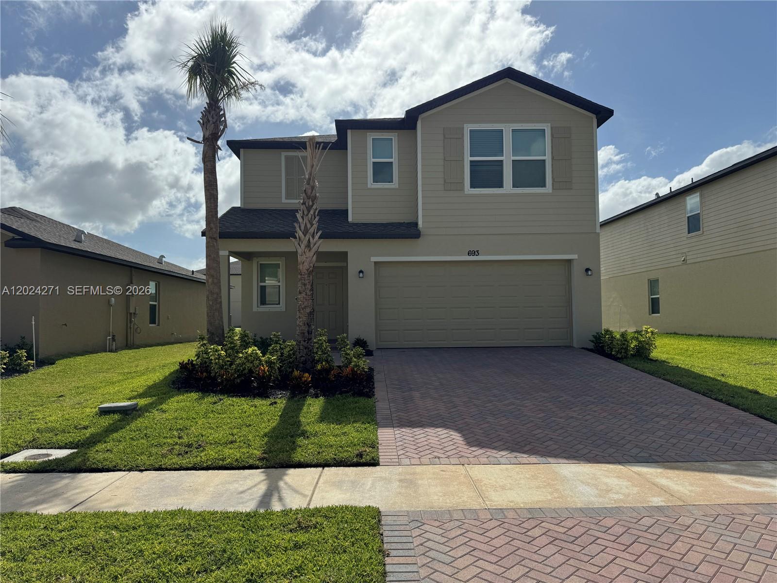 693 Carlyle Way Fort Pierce, FL 34947 - Photo 18 of 19 a front view of a house with a yard and garage