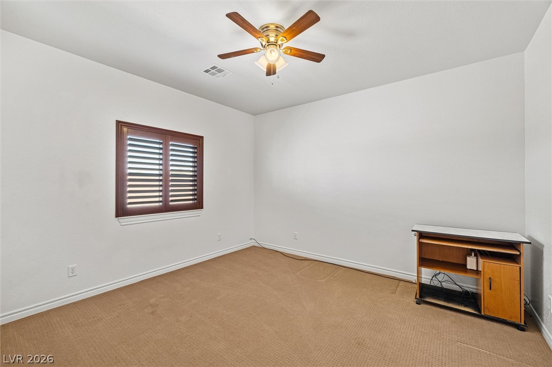 6720 Stubblefield Drive Pahrump, NV 89061 - Photo 19 of 51 A well-lit room featuring a decorative ceiling fan and rich wooden window blinds.