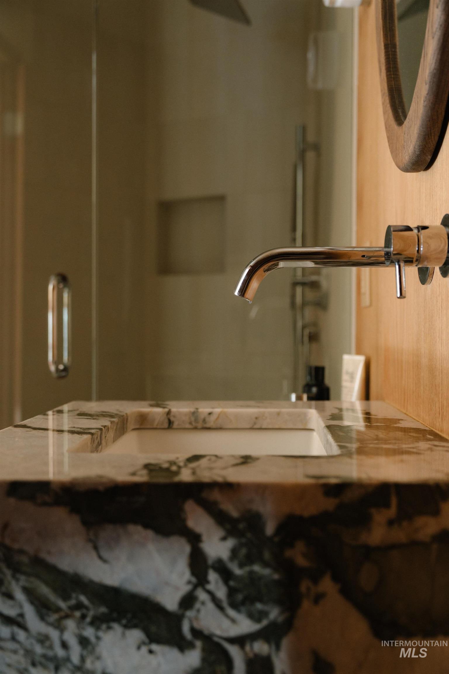208 Georginia Road, Unit A Ketchum, ID 83340 - Photo 16 of 30 Integrated stone vanity with a rectangular basin, wall-mounted chrome faucet, and wood-finish wall paneling