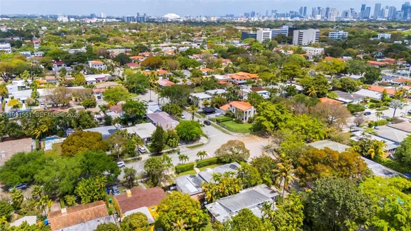 an aerial view of residential houses with outdoor space and trees