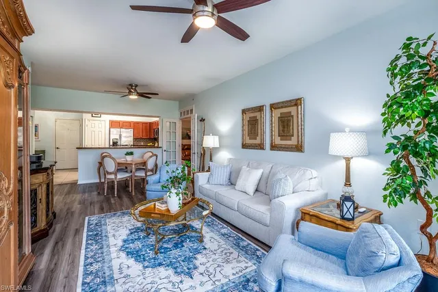 a living room with furniture a flat screen tv and a potted plant