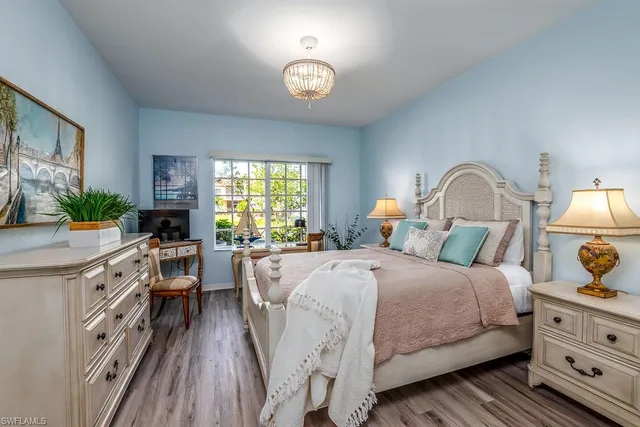 a bedroom with a bed and a dresser next to a window