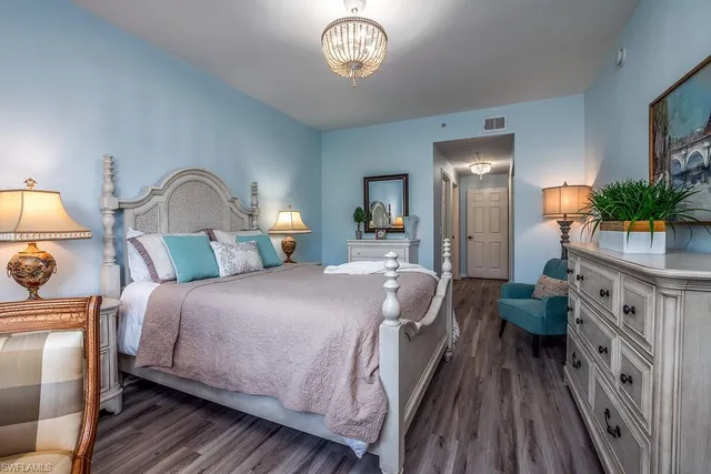 a bedroom with bed and a chandelier