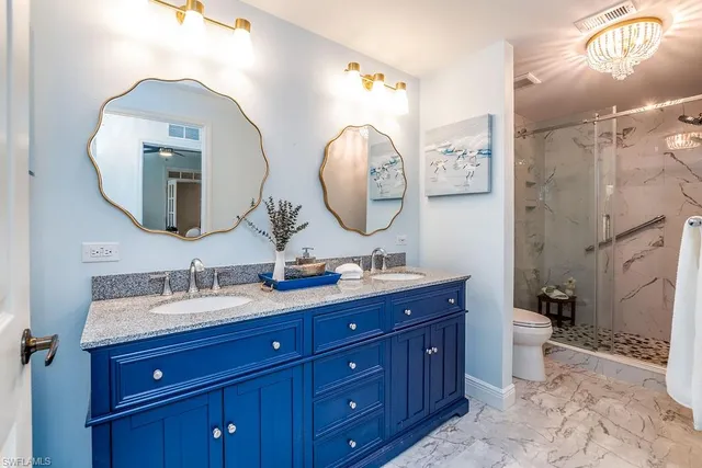 a bathroom with a double vanity sink toilet and a mirror