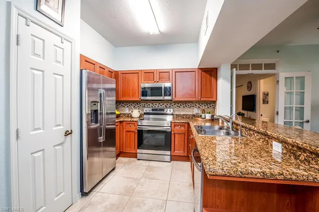a kitchen with stainless steel appliances granite countertop a stove refrigerator and a sink