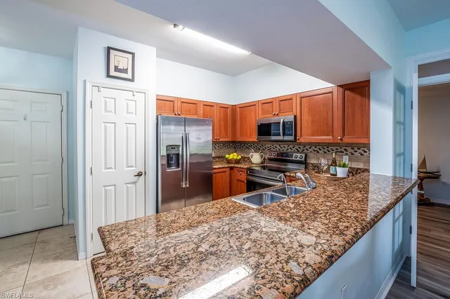 a kitchen with stainless steel appliances granite countertop a refrigerator stove and oven