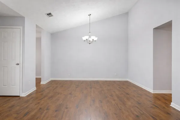 a view of a room with wooden floor and white walls
