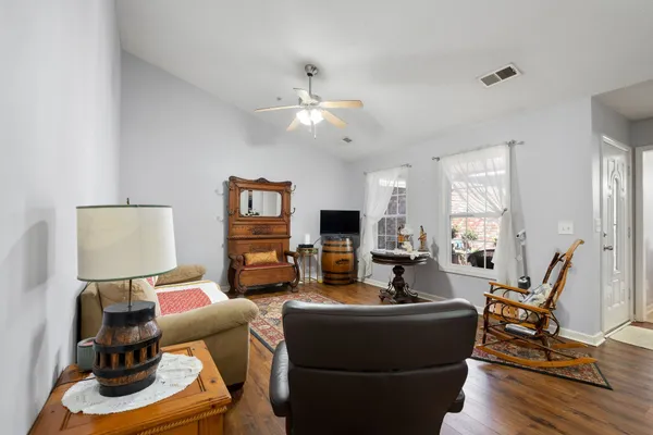 a living room with furniture and wooden floor
