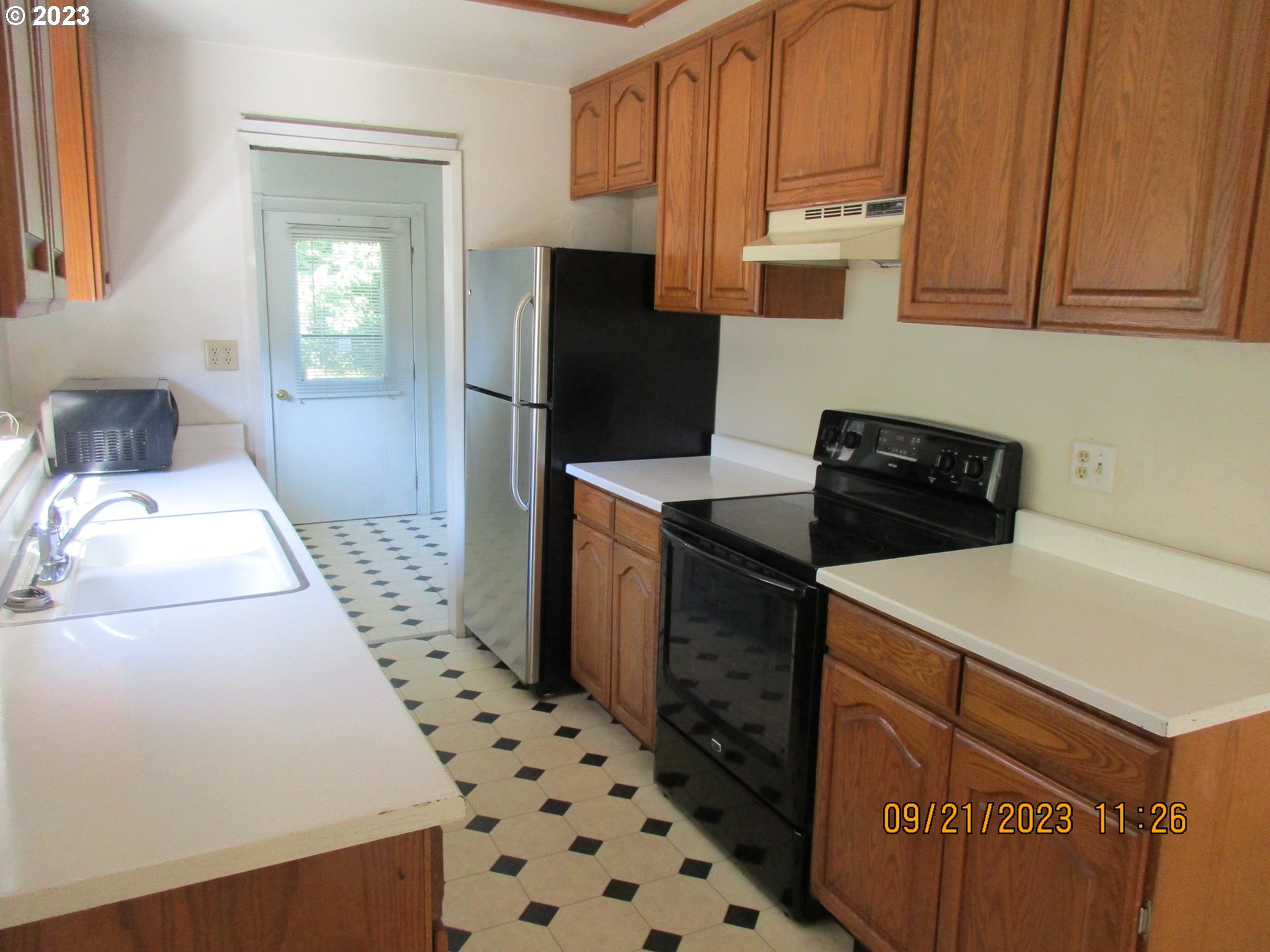 4609 Melrose Road Roseburg, OR 97471 - Photo 4 of 17 a kitchen with a sink a refrigerator and cabinets