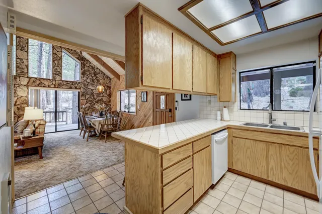 a kitchen that has a sink and chairs in it