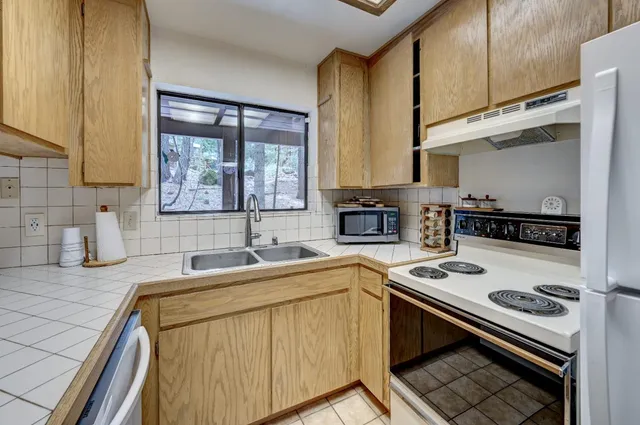 a kitchen with a sink stove top oven and cabinets