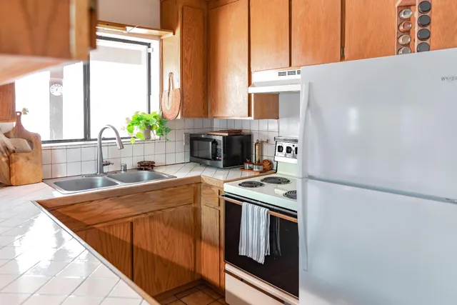a kitchen with stainless steel appliances granite countertop a sink stove and refrigerator