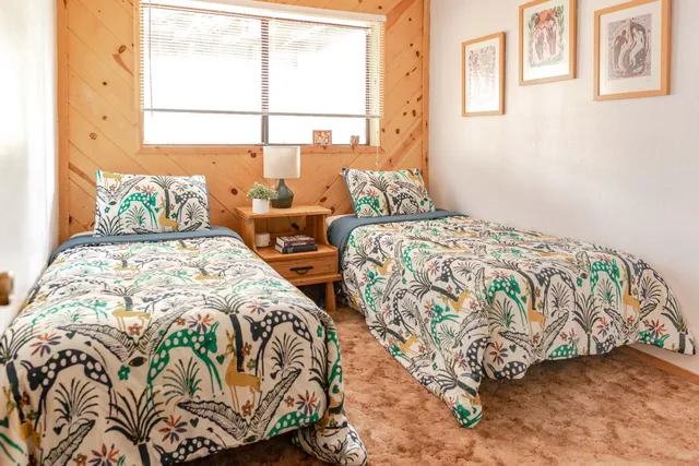 a bedroom with two beds and a window