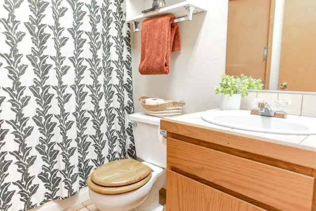 a bathroom with a sink a toilet and a mirror