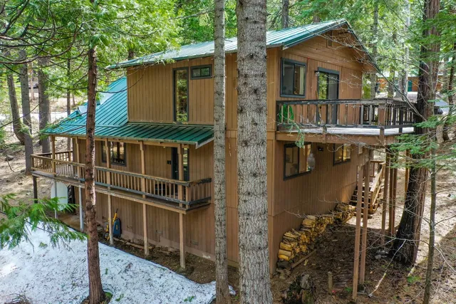 a front view of a house with a yard covered with trees