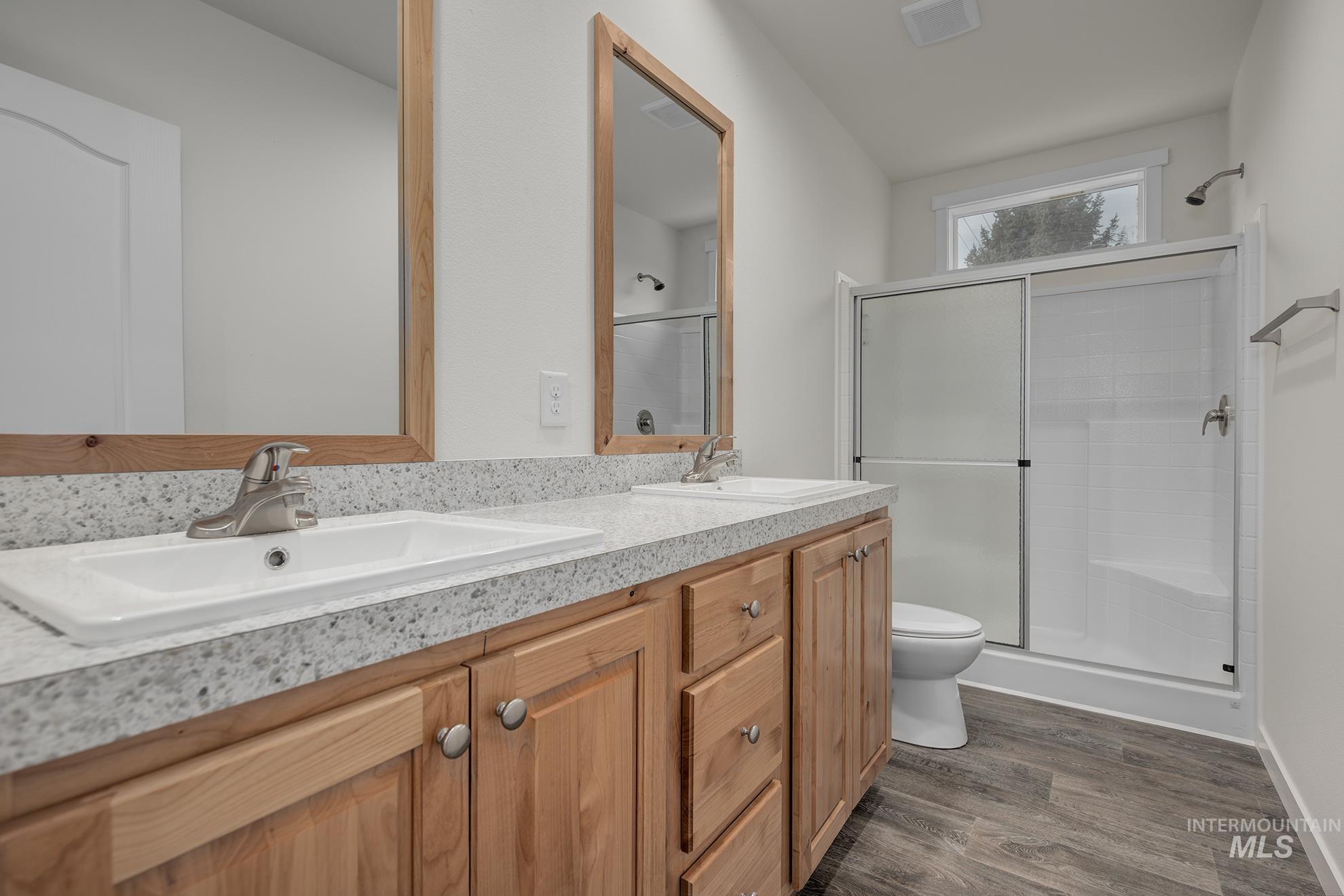 2750 Alden Road, Unit 8 8 Fruitland, ID 83619 - Photo 13 of 31 Bathroom featuring double vanity, a shower stall, and dark wood-style flooring