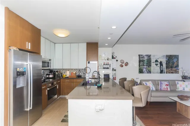 a kitchen with stainless steel appliances granite countertop a sink a refrigerator and a stove