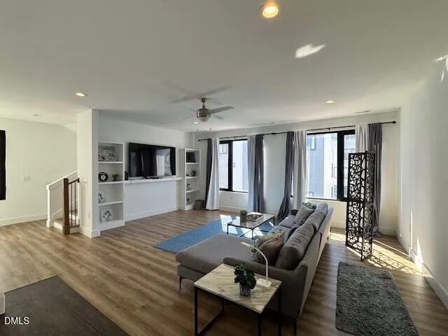 a living room with furniture flat screen tv and wooden floor