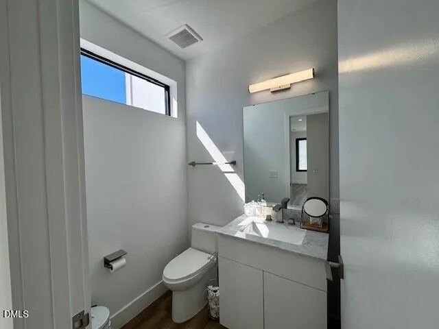 a bathroom with a granite countertop toilet and a sink